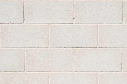 Pared de bloques de hormig&oacute;n gris claro con textura uniforme.