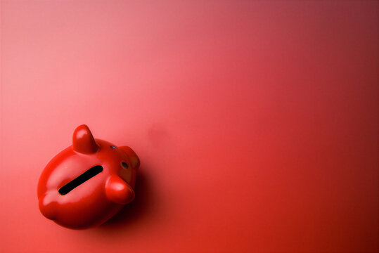 Red Piggy bank on a gradient red background. A savings box containing and displaying banknotes, symbolizing finance and wealth, saving, and spending.