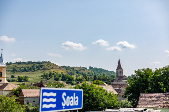 There is a blue sign blurred, unfolds beneath the open sky across Soala, Romania in blue hour glow