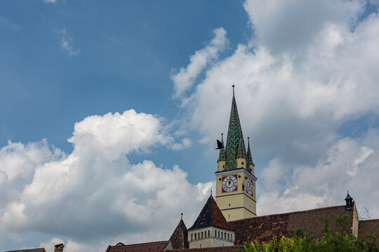 beneath the open sky across Soala, Romania, clock tower on the top of a building, bird flying by