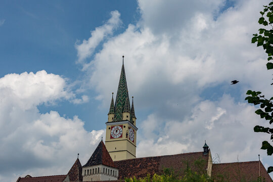 There is a clock tower on the top of a building beneath the open sky across Soala, Romania