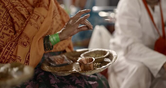 Close-up of aahuti being offered in hawan kund during pooja, showcasing flames, rituals, and sacred Hindu worship practices