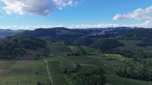 Vista panor&acirc;mica de vale cercado por montanhas verdes revela paisagem natural extensa, vegeta&ccedil;&atilde;o preservada e horizonte sob c&eacute;u azul com nuvens.