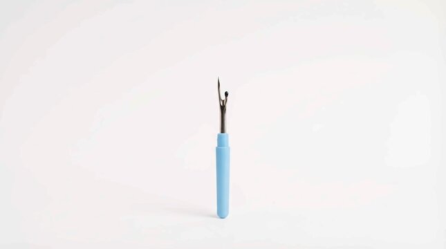 Close-up of a light blue seam ripper on a clean white background