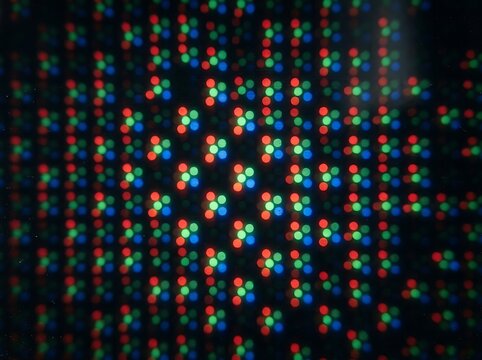 IA generated, extreme macro photography of a digital screen display showing a vibrant grid of RGB pixels and sub-pixels creating a technical textured pattern with multicolored light dots.