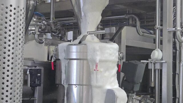 Excessive foam overflowing from industrial soybean processing machinery in food production plant