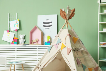 Cute wigwam with garland in stylish child's room, closeup. Space for text © New Africa