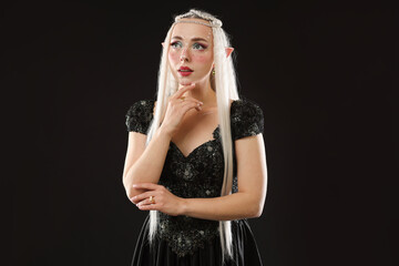 Naklejka premium Beautiful girl dressed as elf on black background