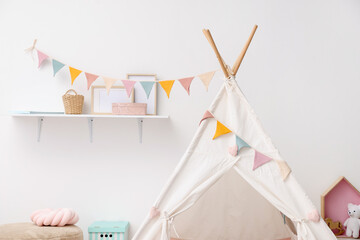Cute wigwam with garland in stylish child's room, closeup. Space for text © New Africa