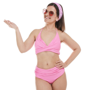 Woman in pink swimsuit and sunglasses pointing at something on white background