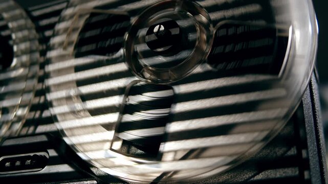 Tape audio music player, VHS studio magnetic tape, vintage retro spool reel to reel player and recorder, magnetic tape data storage close up, music studio. 