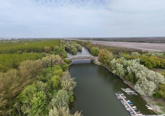 Fototapeta premium Aerial view of bridge over river oxbow with lush green landscape