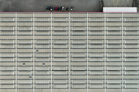 Aerial view of the industrial roof of the Centrale Termoelettrica Santa Barbara Enel with repeating skylights and a row of parked cars in Santa Barbara, Toscana, Italy.