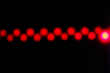 Abstract glowing red light patterns on a dark background. Vibrant bokeh effect with geometric glowing shapes © Aang
