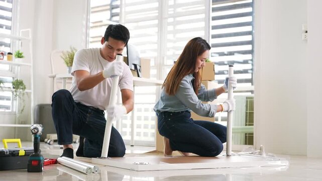 Self-assembly furniture concept. Young couple moving into new apartment or assembly furniture .