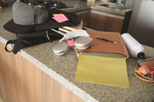 Backpack, laptop, and headphones on a counter, forming a temporary study workspace