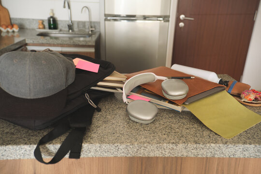 Backpack, books, and headphones creating a study area in a modern kitchen