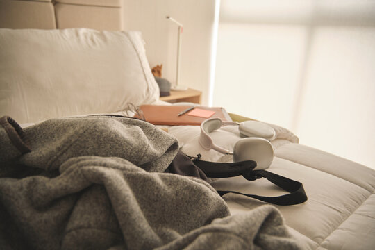 Bedroom study area featuring modern headphones and a notebook on a comfortable bed