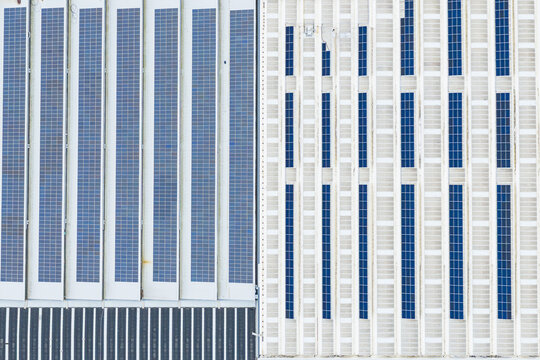 Aerial view of solar panels installed on a large industrial roof with geometric patterns and blue photovoltaic cells Leccio, Toscana, Italy.