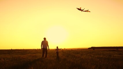 Fototapeta premium Family fun in park with child, flying kite. Father young son fly kite into sunny sky on natural lawn. Family weekend, father and child son playing. Family picnic in nature. Parent raising child boy