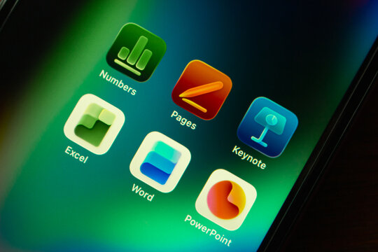 Quito, ECUADOR - Feb 3 2026 : Close-up of an iPhone screen displaying Apple Numbers, Pages, and Keynote alongside Microsoft Excel, Word, and PowerPoint.