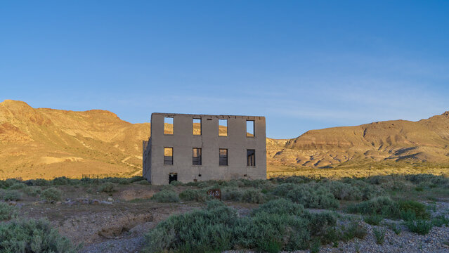 Remains of an old structure in the Rhyolite ghost town, Nevada, framed by sunlit mountains at sunrise. Near Beatty, March 2026.