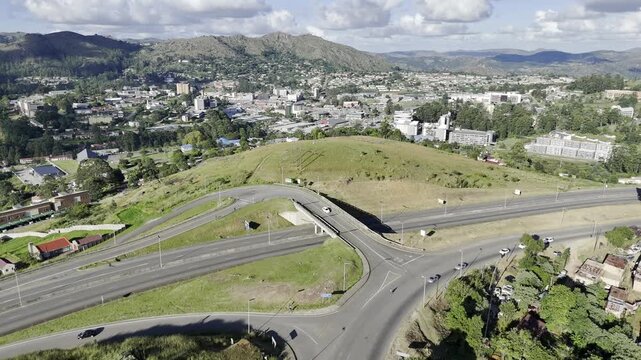Drone flies north over highway and into the city in the late afternoon in Mbabane, Eswatini