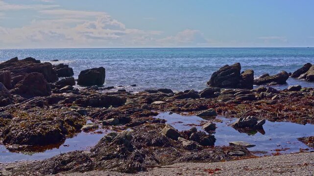 4K coastal video of calm ocean waters and rocky tide pools in Cornwall