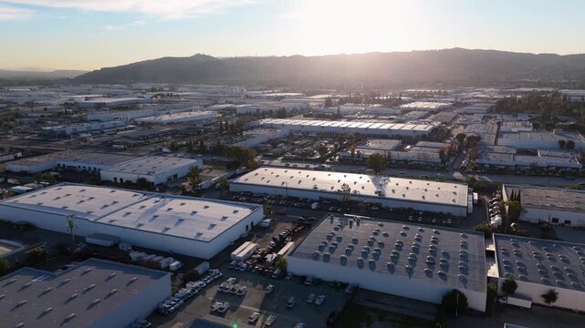 Aerial view of warehouse district at sunset with city sprawl