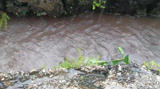 a gutter where the water flows fast when it rains, dangerous for small children with a strong current