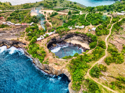 Aerial view of Broken Beach featuring the iconic circular rock formation and turquoise water surrounded by lush green cliffs in Nusa Penida, Bali, Indonesia.