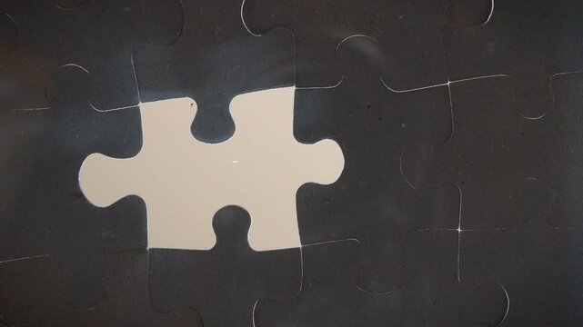 Close up low angle hand placing pieces to complete the puzzle