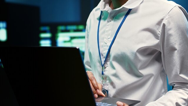 Experienced engineer in data center fixing network issues affecting server performance and connectivity, leading to slow transfer rates and poor client communication, close up