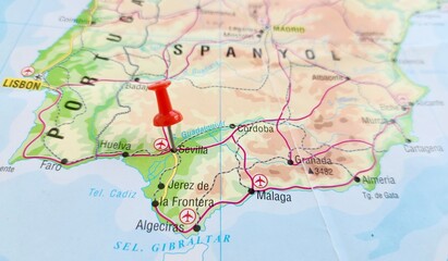 Fototapeta premium View of Seville, is the capital and largest city of the Spanish autonomous community of Andalusia and the province of Seville, on a geographical map of Europa, marked with red push pin