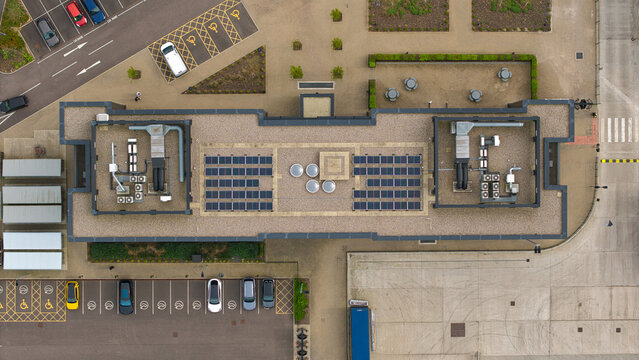 Aerial view of a modern building roof with solar panels and HVAC systems at Appleby Magna industrial park, Appleby Magna, England, United Kingdom.