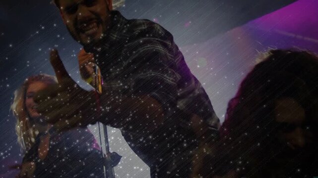 Lead singer launching music pointing camera engaging fans and gripping mic confetti swirling around