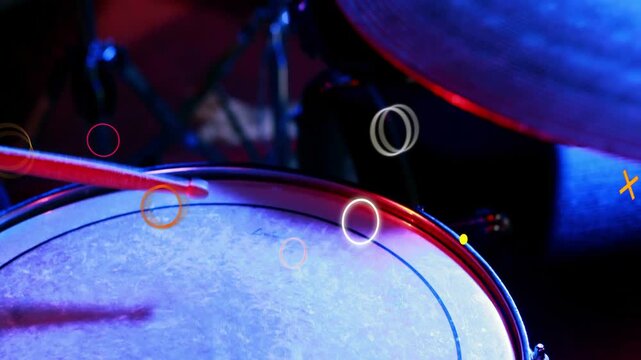 Drumstick entering left and striking drum head on music stage, animated neon shapes syncing to hits