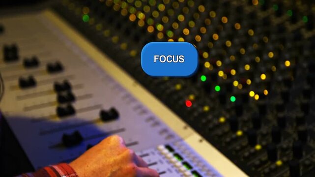 Reacting to onscreen FOCUS label, tech's right-hand in red plaid adjusting fader at studio to mix