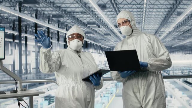 EDA engineers in microchip smart factory developing advanced electronics automation process. Experts using simulation software on devices to optimize semiconductor design flow, camera B