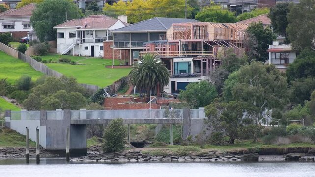 New house construction and older residential architecture overlooking the Maribyrnong River and pedestrian bridge, Ascot Vale, Melbourne, Australia. A liveable environment and waterfront living