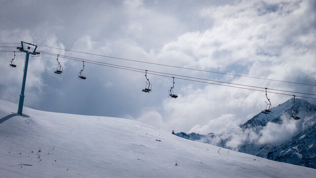 Ski lift over snowy mountain slope in Las Lenas Mendoza Argentina under dramatic cloudy sky.
