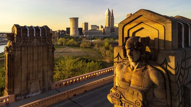 Art deco statue at sunset with city skyline in the distance - Cleveland, Ohio
