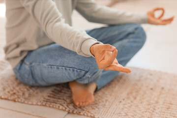 Fototapeta premium Young man meditating on mat at home, closeup