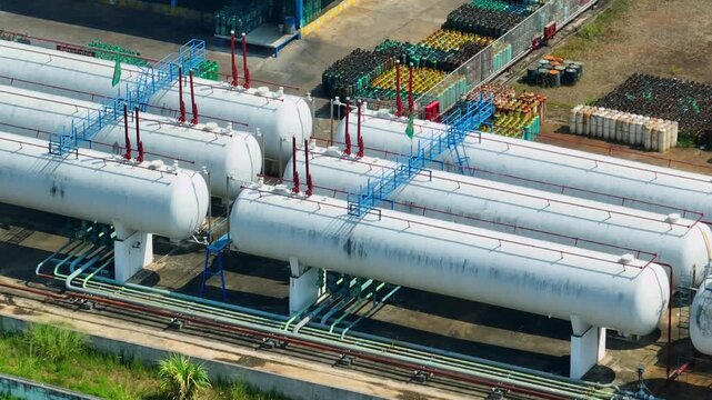 High-angle drone shot of an industrial gas plant with aligned storage tanks, illustrating fuel storage capacity, processing infrastructure, and energy logistics supporting modern economies worldwide.

