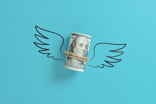 Roll of us dollar money with wings.