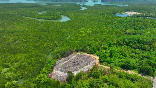 High-angle drone shot of a garbage dump encroaching on mangrove woodland, illustrating modern global concerns about pollution, habitat loss, and the urgent need for sustainable waste solutions. 4k.