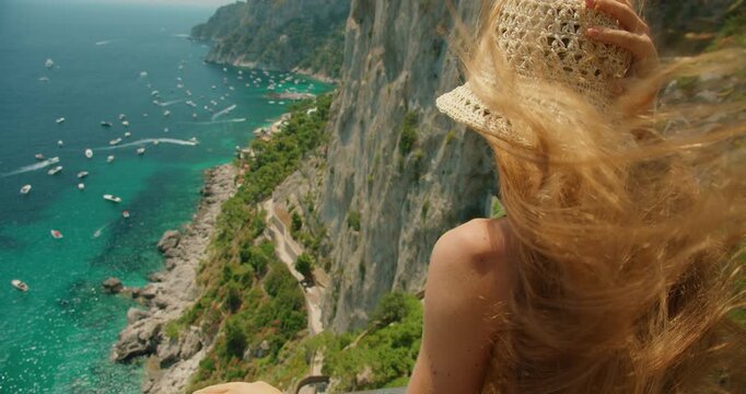 Close view of woman enjoying summer panorama above Marina Piccola from Gardens of Augustus Capri Italy