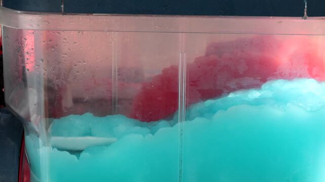 Stockholm, Sweden Red and blue ice slush cooling drink mixing in a drink machine or dispenser. 