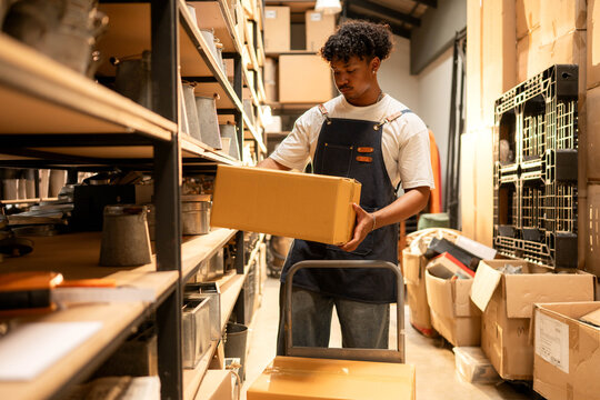Warehouse worker lifting and moving boxes in a small business