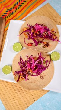 Gourmet taco, Ensenada-style fried fish, garnished with pickled onions, macha salsa, and purple cabbage. Camera rotating from above